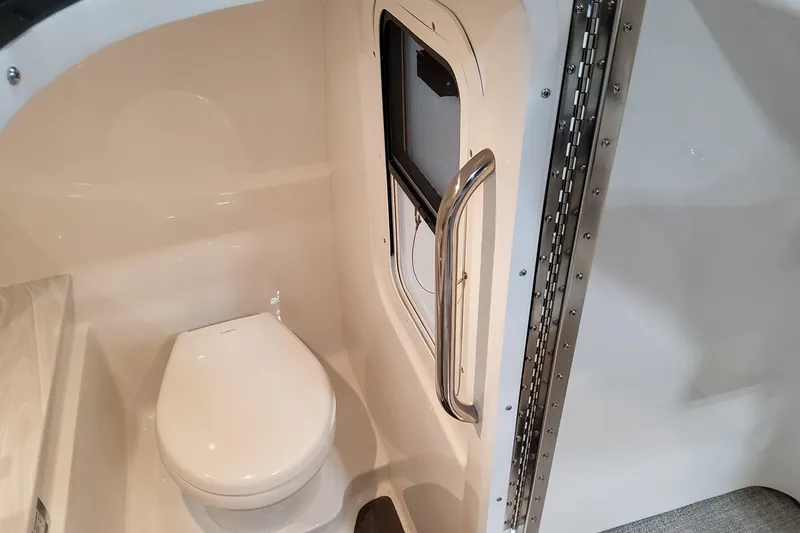 Slide: The Image of Interior of 2026 Formula 310 Bowrider I/O boat featuring a compact marine toilet. - 47