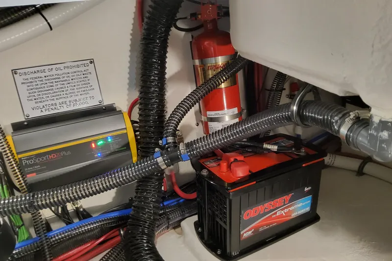 Slide: The Image of 2026 Formula 310 Bowrider I/O engine compartment with battery, charger, and fire extinguisher. - 66