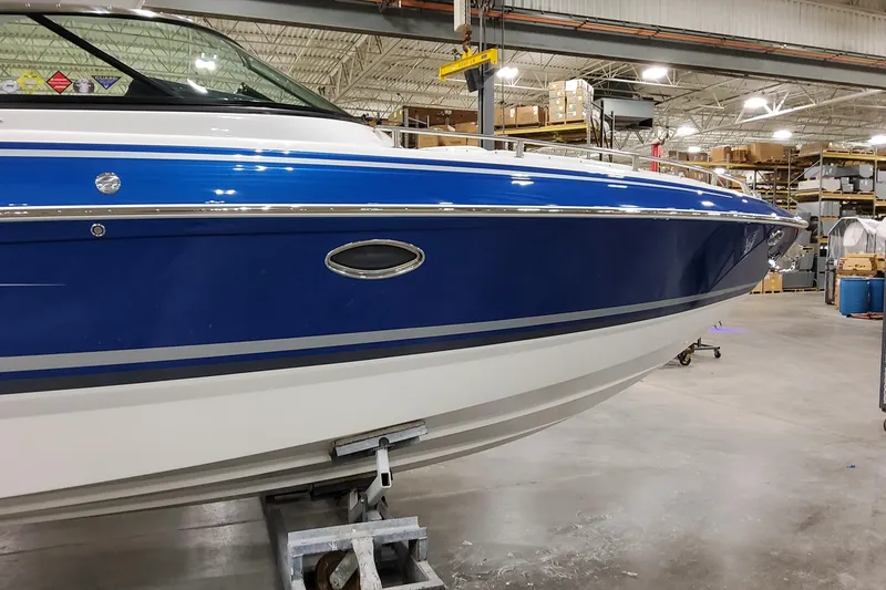 Slide: The Image of 2026 Formula 310 Bowrider I/O boat in a warehouse, showcasing sleek blue and white design. - 7