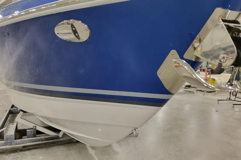 Slide: The Image of 2026 Formula 310 Bowrider I/O boat, blue hull, chrome details, in a workshop setting. - 8