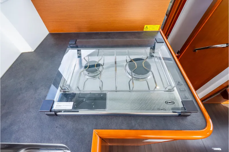 Slide: The Image of 2017 Beneteau Swift Trawler 30 kitchen with a two-burner stove and glass cover. - 17