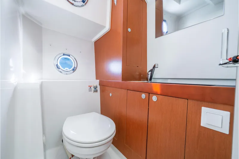 Slide: The Image of Bathroom interior of 2017 Beneteau Swift Trawler 30 with wooden cabinets and porthole. - 20