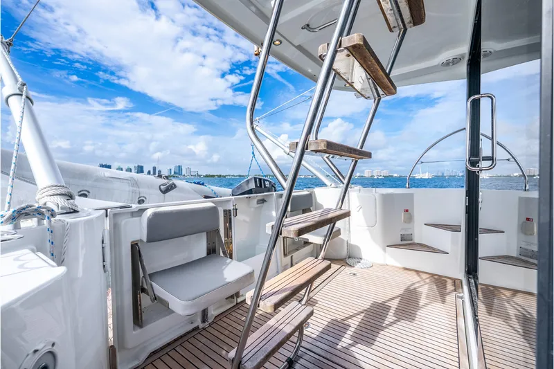 Slide: The Image of 2017 Beneteau Swift Trawler 30 deck with stairs, ocean view, and city skyline. - 23