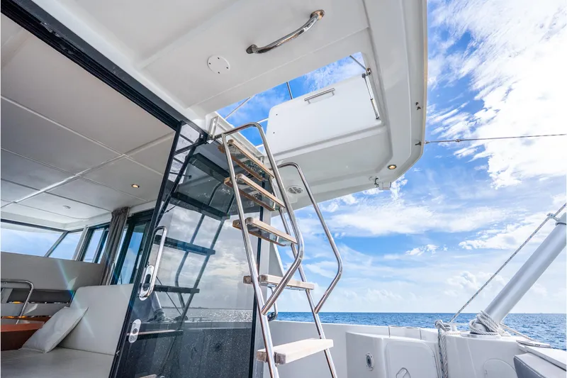 Slide: The Image of 2017 Beneteau Swift Trawler 30 interior with stairs, ocean view, and blue sky. - 25