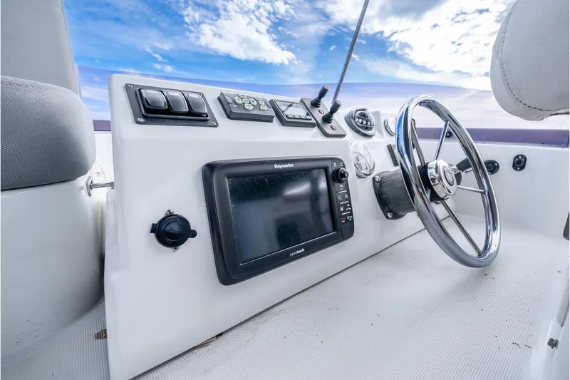 Slide: The Image of 2017 Beneteau Swift Trawler 30 helm with navigation controls and steering wheel. - 33