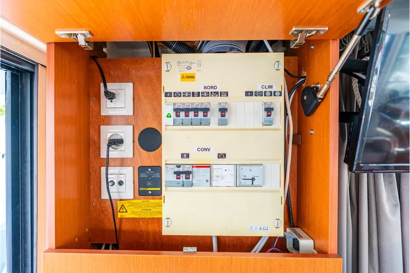 Slide: The Image of Electrical panel inside 2017 Beneteau Swift Trawler 30, showcasing circuit breakers and wiring. - 39