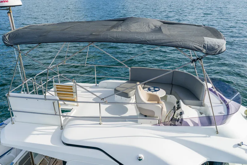 Slide: The Image of 2017 Beneteau Swift Trawler 30 flybridge with seating, canopy, and steering wheel on calm water. - 6