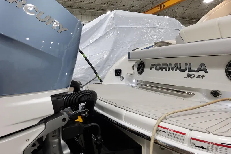 Slide: The Image of 2026 Formula 310 Bowrider OB boat with Mercury outboard engine in a showroom. - 15
