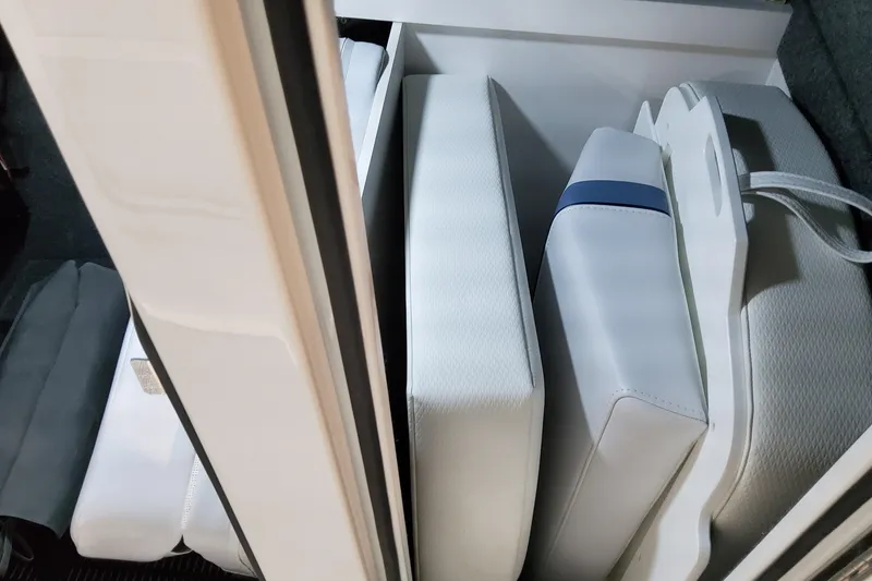 Slide: The Image of 2026 Formula 310 Bowrider OB storage compartment with neatly arranged white cushions. - 44