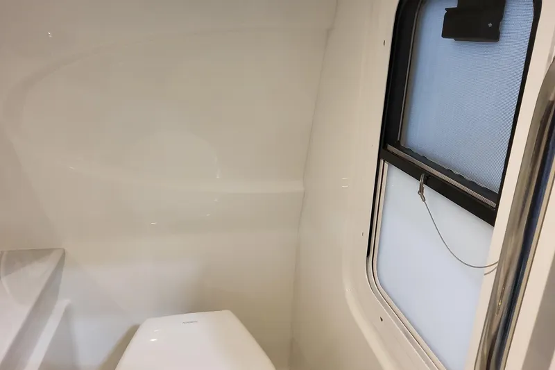Slide: The Image of Interior of 2026 Formula 310 Bowrider OB boat, featuring a compact bathroom with window. - 58