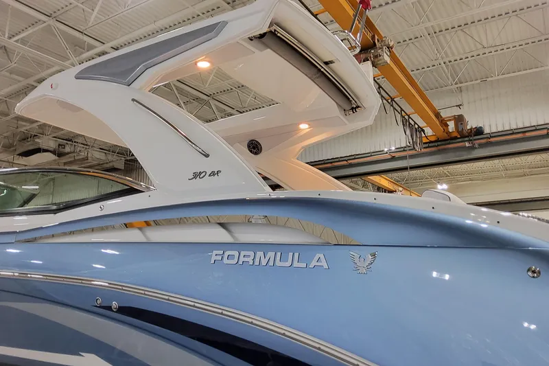 Slide: The Image of 2026 Formula 310 Bowrider OB boat in a showroom, showcasing sleek design and branding. - 7