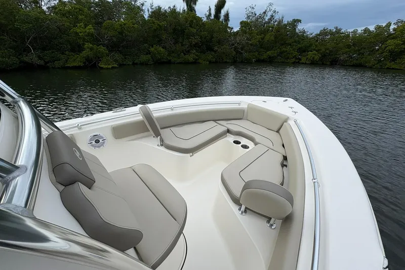 Slide: The Image of 2023 Key West 219 FS boat interior with cushioned seating, on calm water. - 11