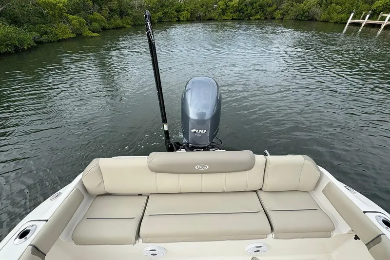 Slide: The Image of 2023 Key West 219 FS boat with Yamaha engine, beige seating, and scenic water backdrop. - 17