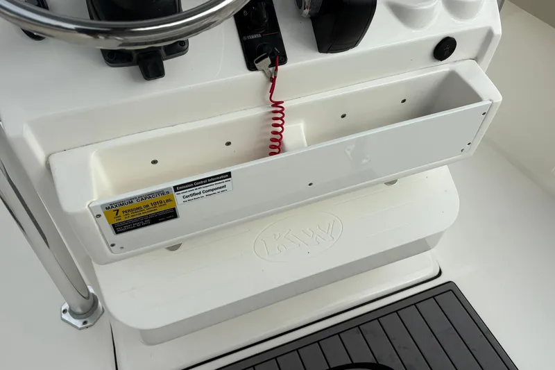 Slide: The Image of 2023 Key West 219 FS boat console with steering wheel and capacity label. - 19