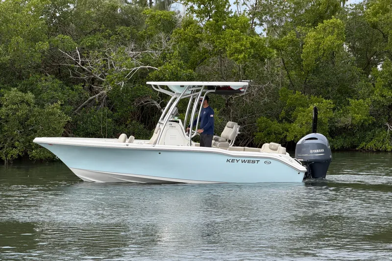 Slide: The Image of 2023 Key West 219 FS boat cruising on calm water near lush greenery. - 4