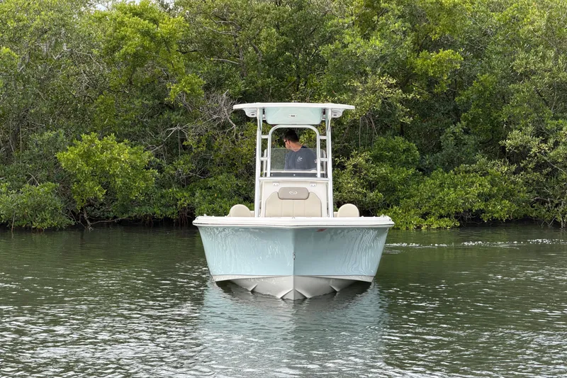 Slide: The Image of 2023 Key West 219 FS boat navigating calm waters near lush greenery. - 5