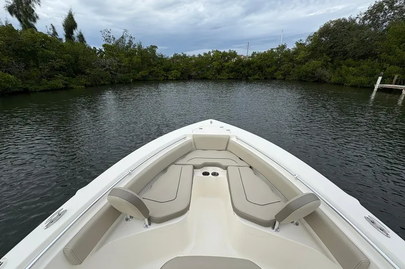 Slide: The Image of 2023 Key West 219 FS boat on calm water, surrounded by lush greenery. - 9