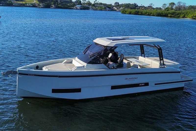 Slide: The Image of 2026 De Antonio Yachts D32 cruising on a serene lake under clear skies. - 4