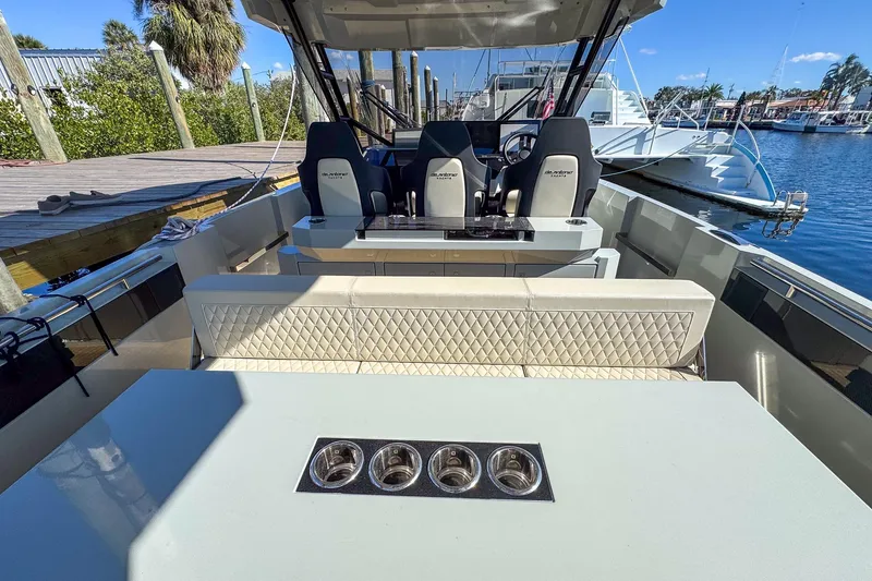 Slide: The Image of 2026 De Antonio Yachts D32 interior with seating and helm, docked at marina. - 14