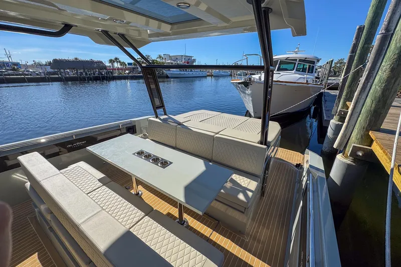 Slide: The Image of 2026 De Antonio Yachts D32 with elegant seating, docked at a marina. - 12