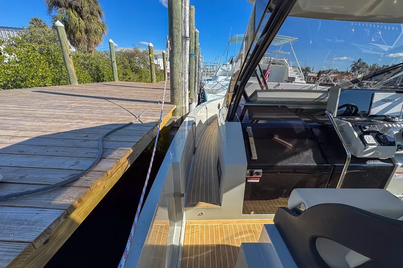 Slide: The Image of 2026 De Antonio Yachts D32 docked, showcasing sleek design and modern cockpit features. - 18