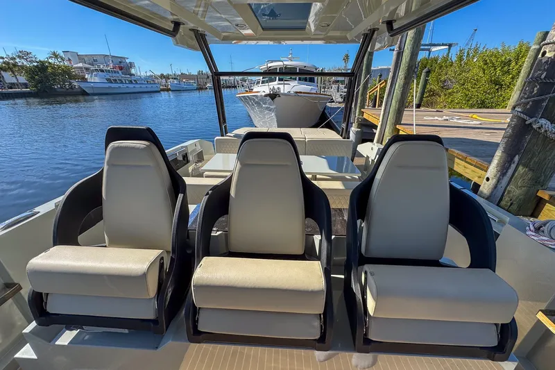 Slide: The Image of 2026 De Antonio Yachts D32 interior with three luxury seats, docked in a marina. - 21