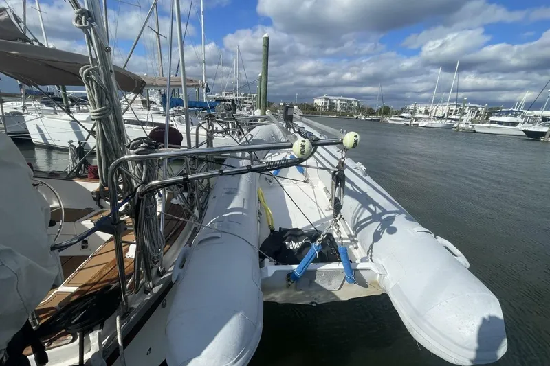 Slide: The Image of 1981 Pearson 36 sailboat docked with inflatable dinghy, under cloudy sky. - 12
