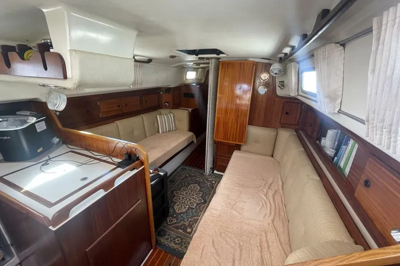 Slide: The Image of Interior of a 1981 Pearson 36 sailboat with cozy seating and wooden cabinetry. - 15
