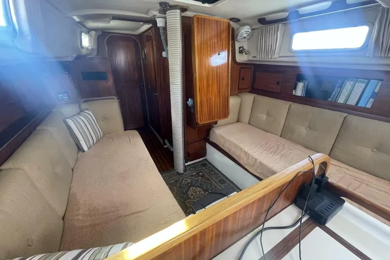 Slide: The Image of Interior of a 1981 Pearson 36 sailboat with cozy seating and wooden cabinetry. - 16