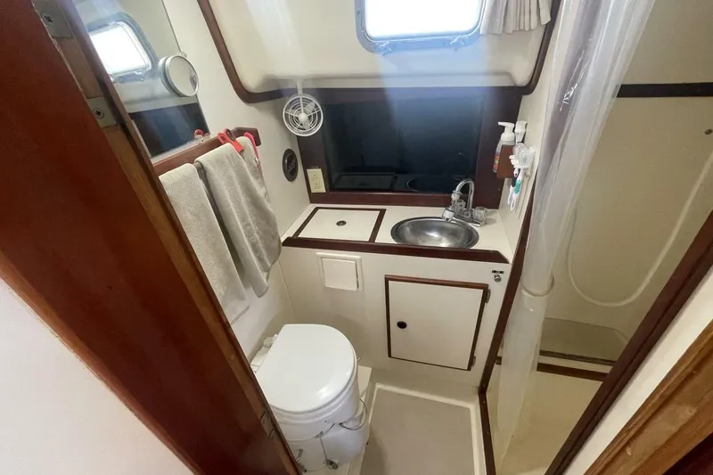 Slide: The Image of Compact bathroom in a 1981 Pearson 36 sailboat with sink, toilet, and shower. - 18