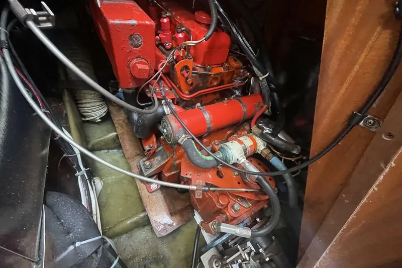 Slide: The Image of Engine compartment of a 1981 Pearson 36 sailboat, featuring red mechanical components. - 24