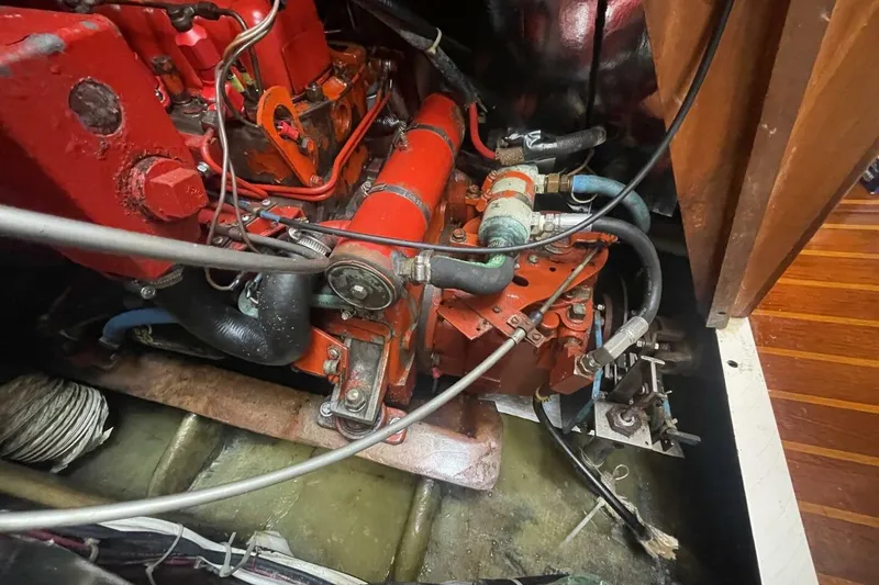 Slide: The Image of Engine compartment of a 1981 Pearson 36 sailboat, showcasing red mechanical components. - 25