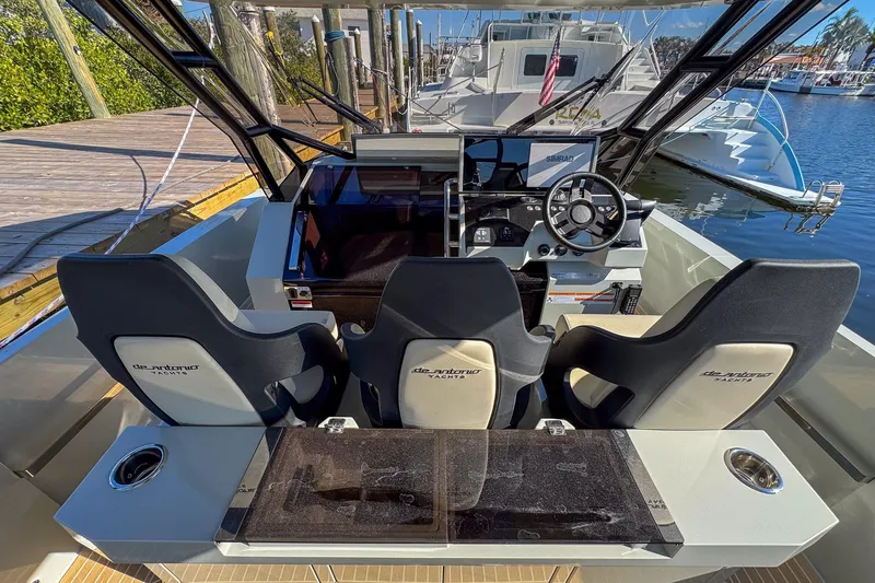 Slide: The Image of 2026 De Antonio Yachts D32 cockpit with modern controls and seating at marina. - 17