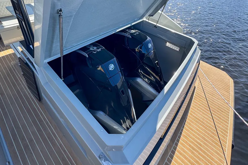 Slide: The Image of 2026 De Antonio Yachts D32 with dual outboard engines, open engine compartment, on water. - 7