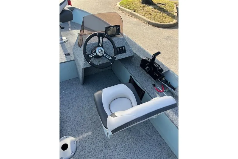 Slide: The Image of 2024 Starcraft Patriot 16 SC boat interior with steering wheel and seat. - 2