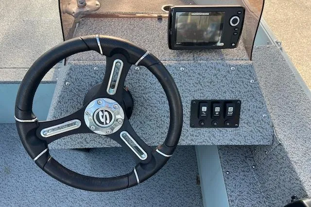 Slide: The Image of 2024 Starcraft Patriot 16 SC boat dashboard with steering wheel and navigation system. - 3