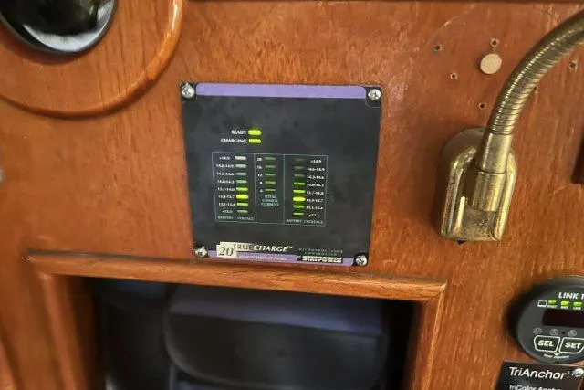 Slide: The Image of Control panel on 1983 Ericson 381 sailboat, featuring battery charge indicators and wooden interior. - 11