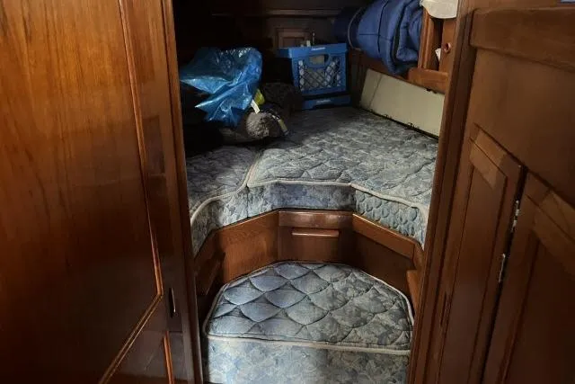Slide: The Image of Interior cabin of 1983 Ericson 381 sailboat with wooden finish and blue bedding. - 14
