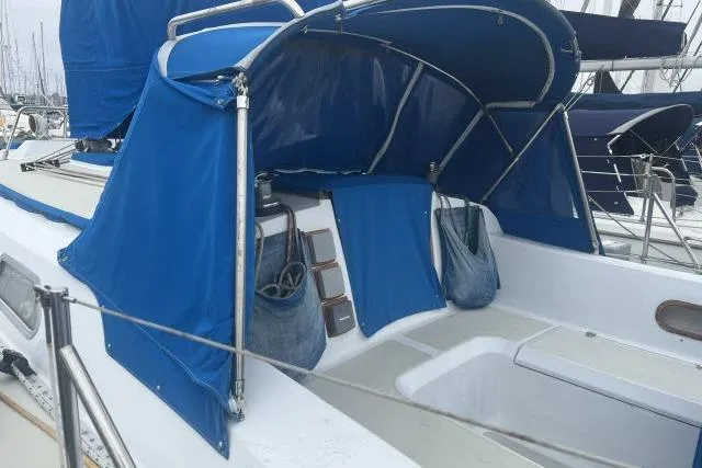 Slide: The Image of 1983 Ericson 381 sailboat with blue canopy and cockpit cover in marina. - 17