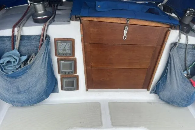 Slide: The Image of 1983 Ericson 381 sailboat cockpit with wooden hatch, navigation instruments, and storage pockets. - 20
