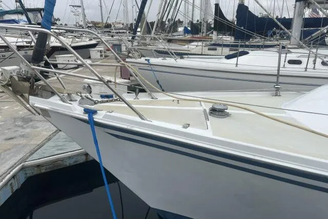 Slide: The Image of 1983 Ericson 381 sailboat docked at a marina, surrounded by other vessels. - 28