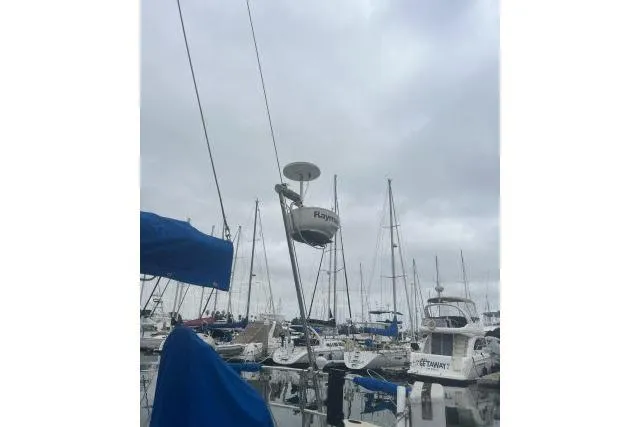 Slide: The Image of Sailboats docked at a marina under cloudy skies, featuring an Ericson 381 from 1983. - 30