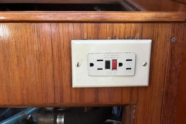 Slide: The Image of GFCI outlet on wooden panel of 1983 Ericson 381 boat interior. - 32