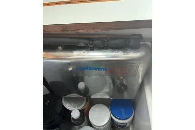 Slide: The Image of 1983 Ericson 381 boat interior with storage compartment and various containers. - 9