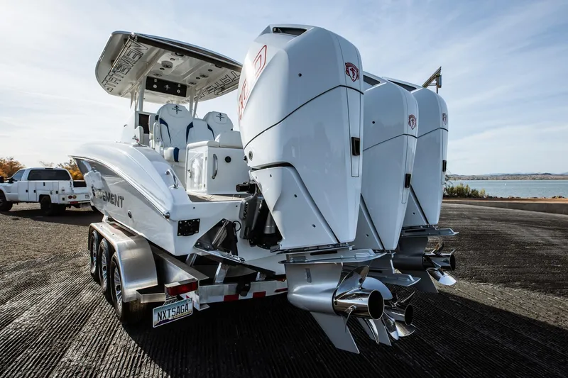 Slide: The Image of 2026 Statement 350 Open boat with triple outboard engines on a trailer by the water. - 14