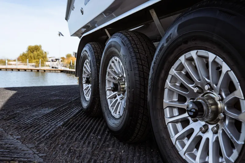 Slide: The Image of Trailer wheels of 2026 Statement 350 Open boat near water. - 17