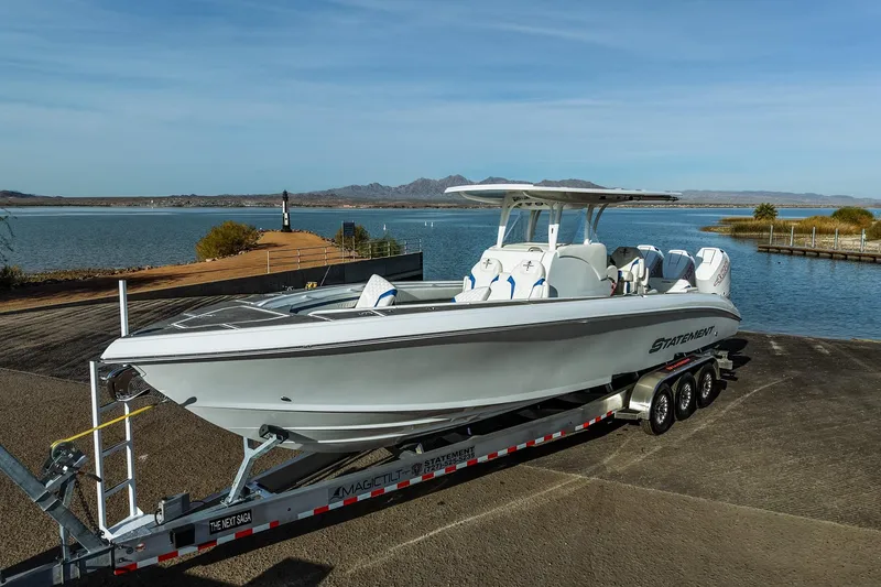 Slide: The Image of 2026 Statement 350 Open boat on trailer by scenic lake backdrop. - 2