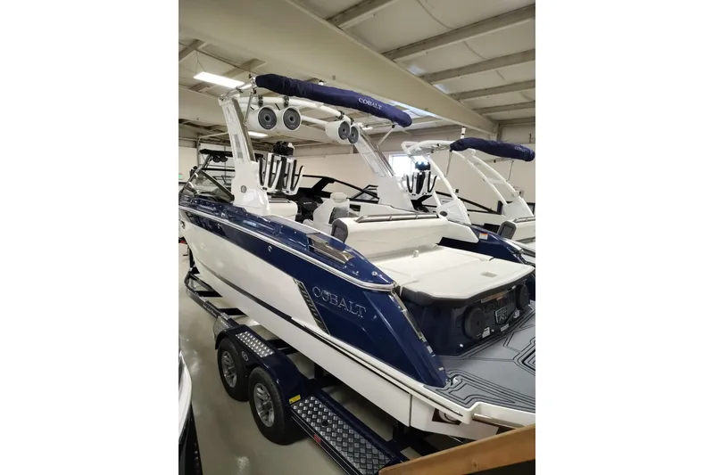 Slide: The Image of 2026 Cobalt R6 Surf boat in a showroom. - 2