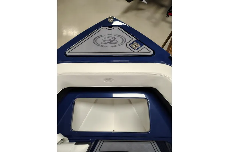 Slide: The Image of 2026 Cobalt R6 Surf boat interior with blue and white seating and storage compartment. - 6