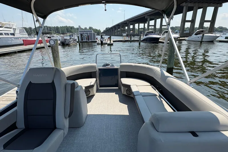 Slide: The Image of 2025 Harris Cruiser 230 pontoon boat interior at marina, featuring spacious seating and elegant design. - 6